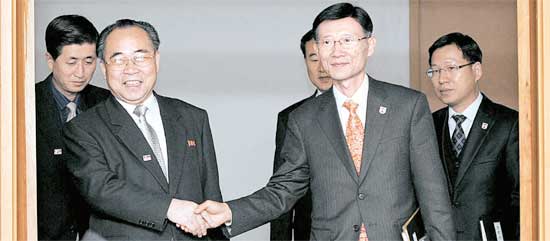 キム・ヨンヒョン韓国側代表団長（右）とチェ・ソンイク北側代表団長が握手している。