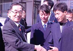 北朝鮮平壌科学技術大学でキム・ジンギョン総長（左）が入学生と握手をしている。（写真提供：北東アジア文化協力財団）