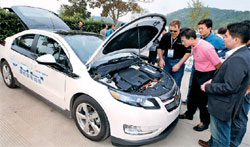 ボルトの試乗会で、記者が同車のボンネットを開いて充電および電気システムに注目している（写真＝ＧＭ大宇）。