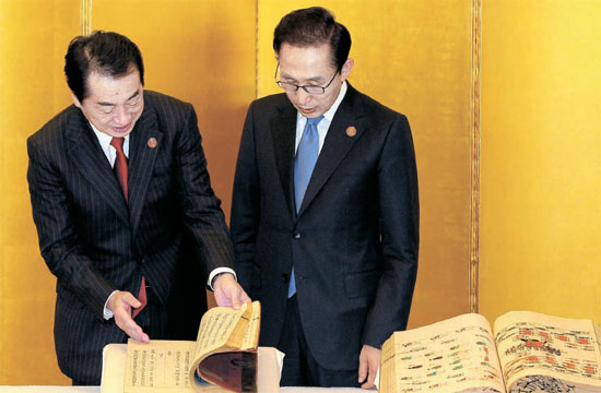 李明博大統領と菅直人首相が１４日に朝鮮王朝儀軌など返還図書を見ている。