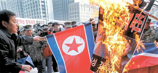 ３０日午後、ソウル光化門前の交差点で、愛国団体総連合会の会員らが「世襲独裁打倒！」と書かれた旗を燃やしている。