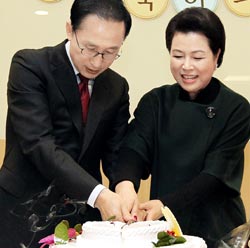 李明博大統領と金潤玉夫人が１７日、青瓦台の職員が準備した誕生日パーティーに出席し、ケーキを切っている。［青瓦台提供］