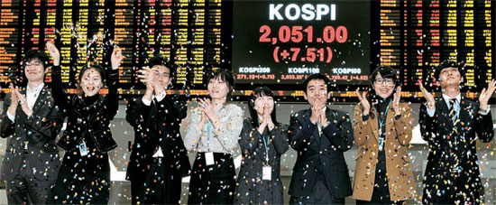 ３０日、ソウル汝矣島（ヨイド）の取引所総合広報館で、コスピ指数が年内最高値で今年の取引を終えたことを祝っている。