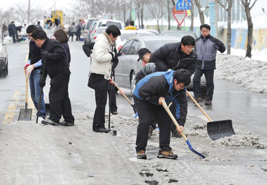 全羅南道木浦市（チョルラナムド・モッポシ）の公務員らが道路の雪を片付けている（写真＝木浦市庁）。