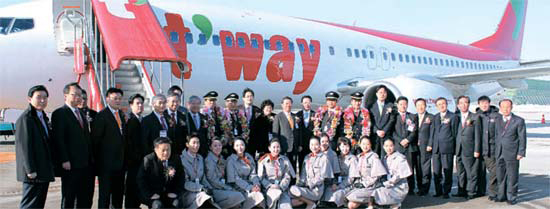 ティーウェイ航空の役職員が金浦空港で２７日、新規導入したボーイング７３７－８００航空機を背景に記念撮影をしている。
