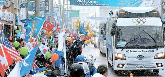 ＩＯＣ調査団を乗せたバスが平昌横渓ロータリーを通過し、平昌郡民およそ１２００人が旗を振りながら歓迎している。
