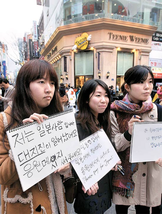 韓国で勉強している日本人留学生がソウル明洞で市民の激励メッセージを受けている。