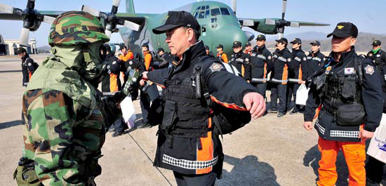 日本で救助活動を行った１１９緊急救助隊が２３日、ソウル空港に到着し、放射能汚染検査を受けている。