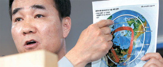 気象庁のキム・スンベ報道官が２９日、放射能が韓国に到達したルートを描いた絵を示して説明している。