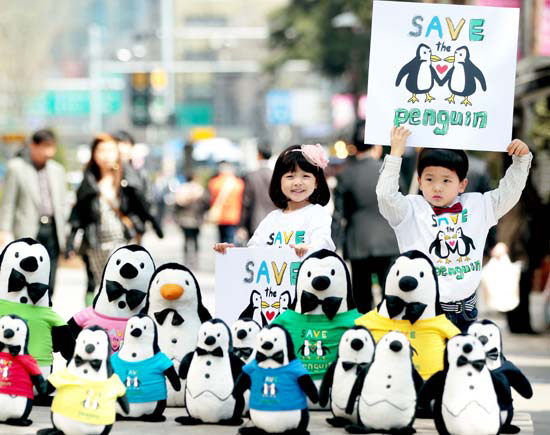 １２日にソウルのロッテ百貨店前で開かれた環境保護キャンペーンでプラカードを持つ子どもたち。