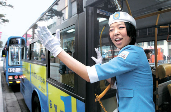 ２０日午前、ソウル・小公洞（ソゴンドン）でバスに乗ろ「オーライ」と叫んでいるバス案内嬢の服を着たコンパニオン。