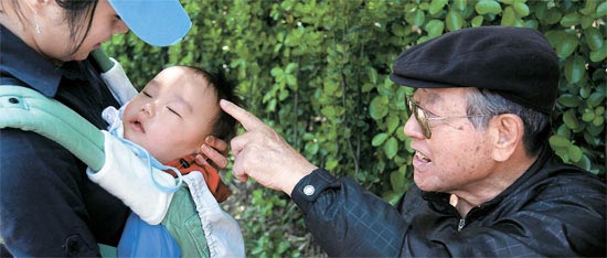 １３日午前、ソウル南山（ナムサン）公園を訪れた金鍾泌元総理が曾孫を見ている。