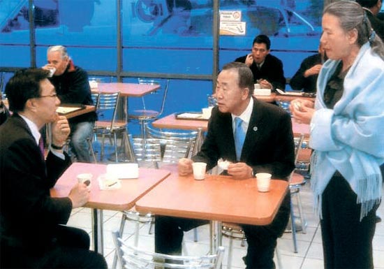アルゼンチンの高速道路サービスエリアでコーヒーとクッキーで朝食をとる潘基文国連事務総長（右から２人目）。マントをまいた人は柳淳沢夫人（写真＝国連事務局）。