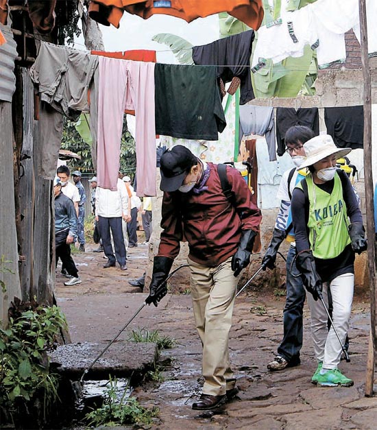 エチオピアを訪問した李明博大統領が９日（現地時間）、アジスアベバのケベナ村で消毒薬をまきながら防疫作業をしている。国家首脳が海外歴訪中にボランティア活動をするのは極めて異例（写真＝青瓦台提供）。