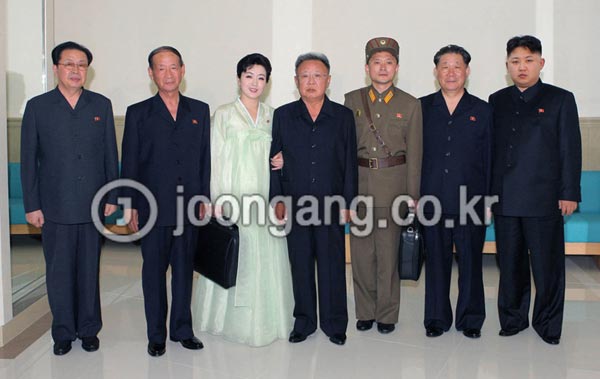 朝鮮中央通信が最近公開した写真。第４次軍人家族芸術小組の独演で「願い」を演じ、特等賞を受けたパク・リョンヒ（左から３番目）と金正日（キム・ジョンイル、左から４番目）国防委員長ら。