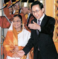 李明博大統領が２５日、青瓦台（チョンワデ、大統領府）で、首脳会談のために訪韓したインドのパティル大統領に会い、会談場に案内している。