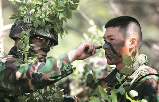 俳優ヒョンビン（写真右）が野外戦術訓練を受けるために偽装している。
