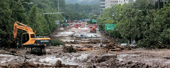 ソウル市災害復旧チームが牛眠山（ウミョンサン）の山崩れで土砂があふれた芸術の殿堂近くの南部循環路で復旧作業をしている。