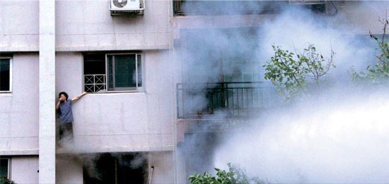 ２９日午後、ソウル・汝矣島（ヨイド）の三益（サムイク）アパートで火災が発生し、住民が煙を避けようと４階の窓で救助を待っている（写真＝読者チャン氏提供）。