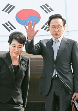 李明博（イ・ミョンバク）大統領と金潤玉（キム・ユンオク）夫人が２０日、ニューヨークへ向かう専用機であいさつしている。