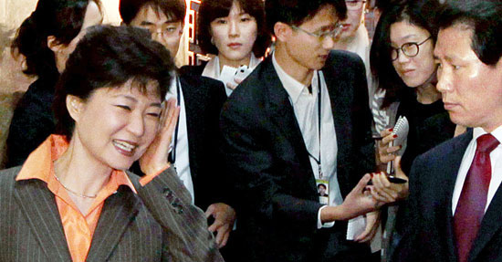 朴槿恵ハンナラ党元代表が１０日、国会本会議場の前で取材中だったある通信社の女性記者の携帯電話にぶつかった後顔をなでている。朴前代表は「大丈夫だ」と話した後笑って本会議場に入った。