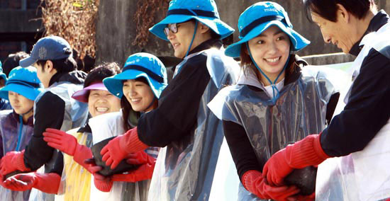 韓国の牛乳メーカー「毎日乳業」の職員と大韓赤十字社のボランティアが２５日、ソウル水色洞（スセクドン）の不遇の人々に練炭を伝達している。