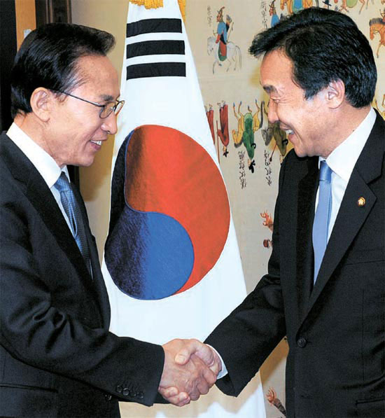 李明博（イ・ミョンバク）大統領が１５日、韓米ＦＴＡ批准のため国会を訪問し、孫鶴圭（ソン・ハッキュ）民主党代表と握手している。