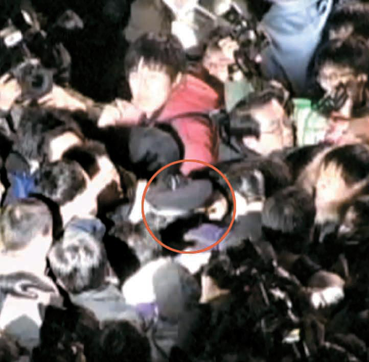 ２６日夜、「韓米ＦＴＡ反対集会」解散を呼びかけようとしていたソウル鍾路（チョンノ）警察署のパク・ゴンチャン署長の頭部に伸びる集会参加者の手。