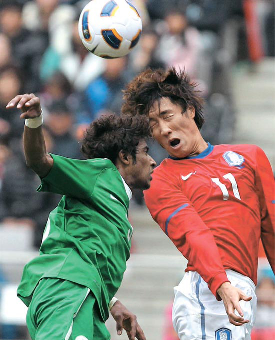 韓国五輪代表チームの?永哲（チョ・ヨンチョル、右）がサウジアラビアの選手と空中のボールを競り合っている。?永哲は前半３４分、キム・ヒョンソンが得たＰＫを決め、決勝点を挙げた。