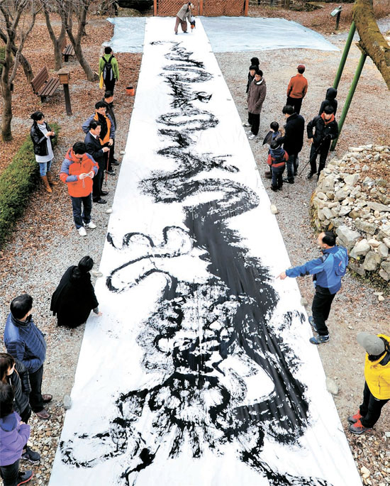 ２０１２年の黒竜年を控え４日に忠清南道公州市（チュンチョンナムド・コンジュシ）の鶏竜山（ケリョンサン）国立公園でイ・ジョンチョル画伯が超大型の黒い竜を描くパフォーマンスを行っている。