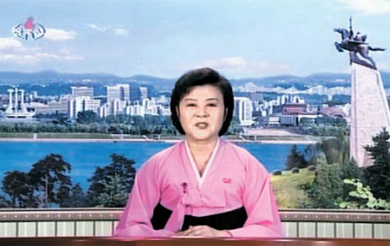 ４月１５日に朝鮮中央テレビ午後５時のニュースを進行中のイ・チュンヒ氏。背景に平壌市街地の姿が見える。