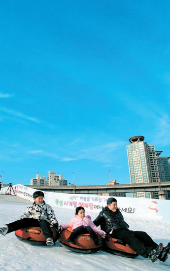 １８日、ソウルのトゥクソム遊園地を訪れた市民が雪ゾリを楽しんでいる。