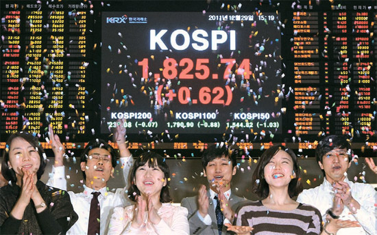 ２０１１年の株式市場が閉場した２９日、ソウル汝矣島（ヨイド）の韓国取引所で職員が色紙を投げて祝っている。