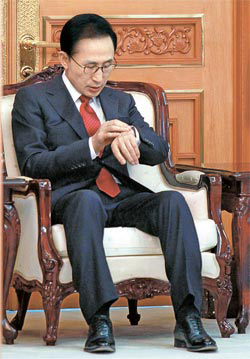 李明博（イ・ミョンバク）大統領が２日、青瓦台（チョンワデ、大統領府）での新年国政演説を控えて、時計を見ている。
