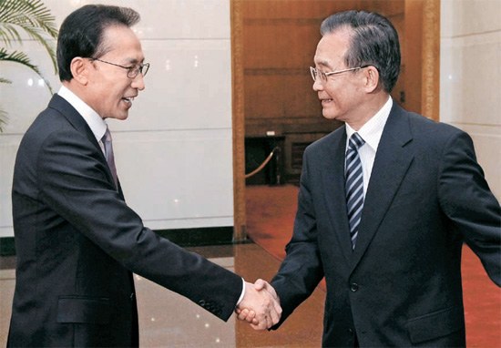 李明博（イ・ミョンバク）大統領が１０日、北京の釣魚台迎賓館で温家宝首相に会い、あいさつを交わしている。