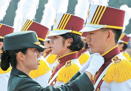 ２３日、国軍看護士官学校の入学式で、先輩生徒が男子新入生の服装を直している。
