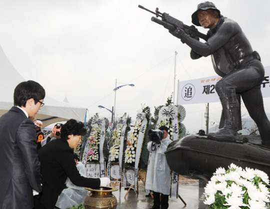 韓国哨戒艦「天安（チョンアン）」爆沈事件の後、将兵救出作業中に殉職した故ハン・ジュホ海軍准尉の銅像の前で、遺族が焼香している。