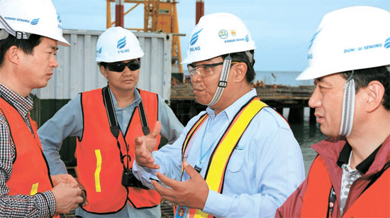 韓日企業の最初のＬＮＧ開発事業現場、インドネシア・スラウェシ島。 韓国ガス公社と三菱商事の関係者がインドネシア人の監督と話し合っている（写真＝韓国ガス公社）。