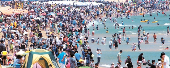 ３日、釜山（プサン）の海雲台（ヘウンデ）海水浴場を訪れた市民らが海に入り暑さをしのいでいる。