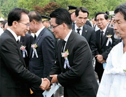 李明博（イ・ミョンバク）大統領（左）が６日、ソウル国立顕忠院で開かれた「第５７回韓国殉国烈士の日追悼式」の後、朴智元（パク・ジウォン）民主統合党非常対策委員長と握手している。右側は姜基甲（カン・キガプ）統合進歩党非常対策委員長。