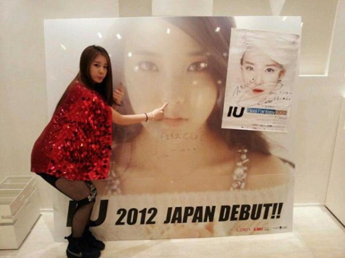 Ｔ－ＡＲＡのジヨンが日本の町中に掲げられているＩＵの大型ポスターの前で膝を半分ほど曲げて立っている（写真＝ＩＵのツイッター）。