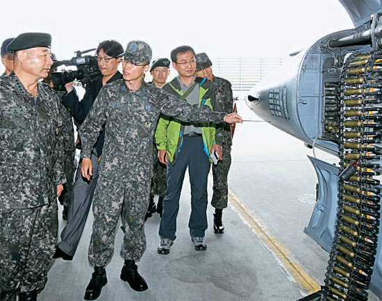 チョン・スンジョ合同参謀議長（左側）が１４日、東海岸軍部隊巡視で空軍江陵基地を訪問して、掩体壕（格納庫）で機関銃弾薬を装填中のＦ－５戦闘機を確認している。