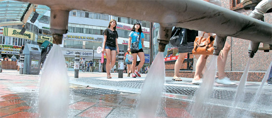 大邱市東城路（テグシ・トンソンロ）で散水車が猛暑で熱くなった道路の上に水をまいている。