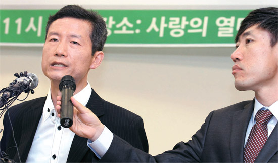 １１４日間にわたり中国国家安全庁に強制拘禁されて２０日に釈放された北朝鮮人権運動家キム・ヨンファン氏（左）が２５日に会した。セヌリ党のハ・テギョン議員がキム氏が発言する間マイクを持っている。