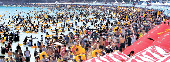 ２９日、釜山（プサン）の海雲台（ヘウンデ）海水浴場を訪れた避暑客が水遊びを楽しんでいる。