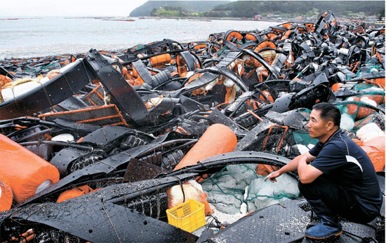 台風１５号が通過した２８日、全羅南道莞島郡（チョンラナムド・ワンドグン）の海岸である漁民が廃墟となったアワビ養殖場を見てため息をついている。