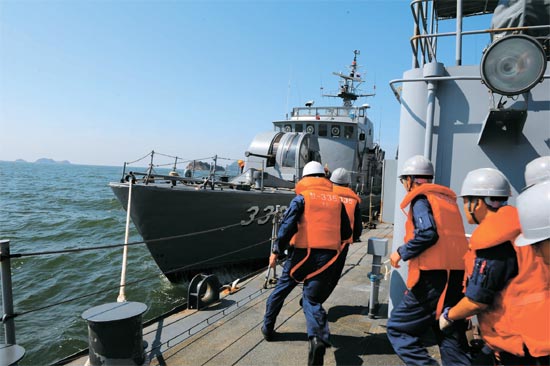 ２５日、延坪島海上の前進基地で海軍将兵が緊急出動命令を受け高速艇に走って向かっている。彼らはいつも５分出動態勢を維持している。（写真＝海軍）
