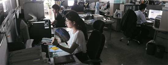 今年の夏、電力等級「注意」段階が発令され、韓国電力取引所の職員がソウル三成洞の事務所で消灯したまま仕事をしている（写真＝中央フォト）。
