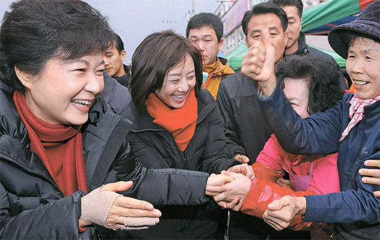 朴槿恵（パク・クネ）セヌリ党大統領候補が２８日、忠清南道礼山の駅前市場で、包帯をした右手の代わりに左手で市場の商人と握手している。