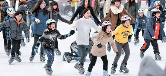 １３日午後、ソウル広場のスケート場を訪れた市民が暖かい休日を楽しんでいる。